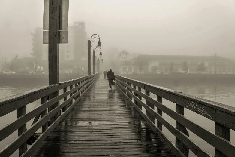 two people walking on a dock in the rain