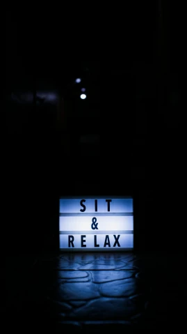 the words sit and relax are illuminated in the dark