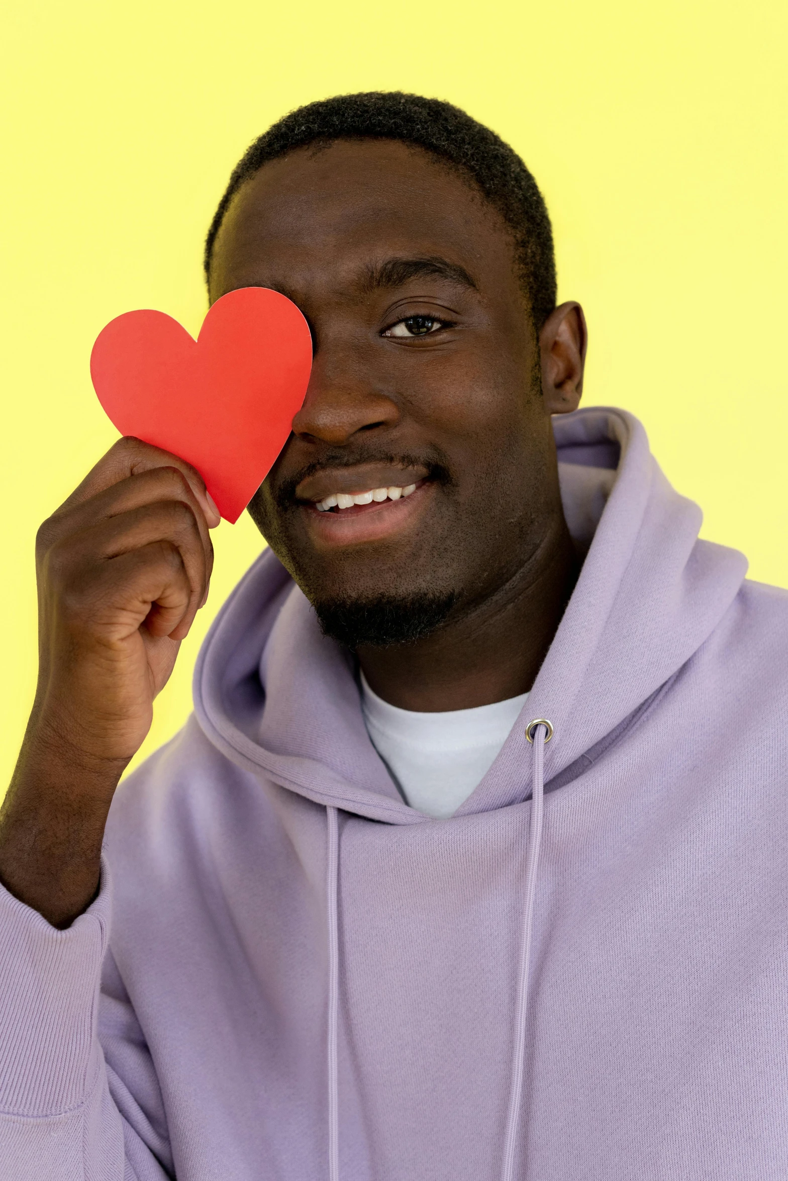 a man holding up a heart shaped paper