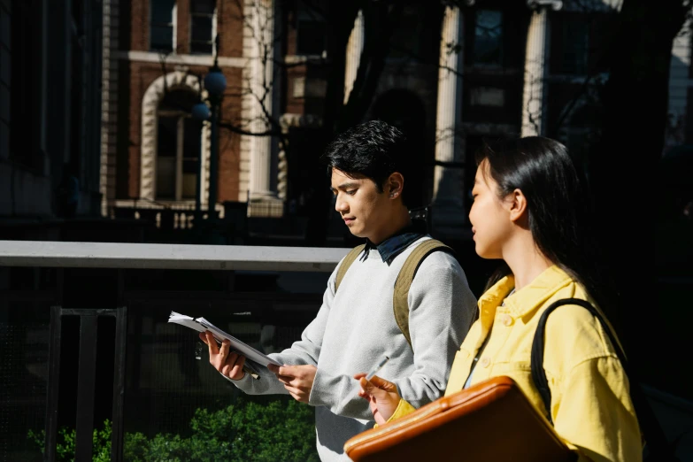 a man and woman stand outside while looking at soing