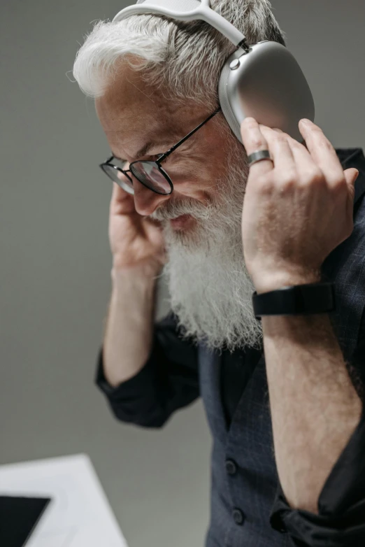 a man wearing glasses and holding a white head phone