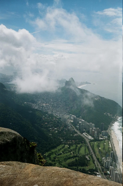 the sky is cloudy and low over a city below the ocean