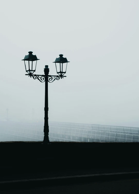 a pole with three lamps standing in front of a large building