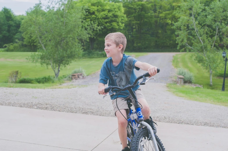 a boy on a bike, sitting with the front wheel slightly bent