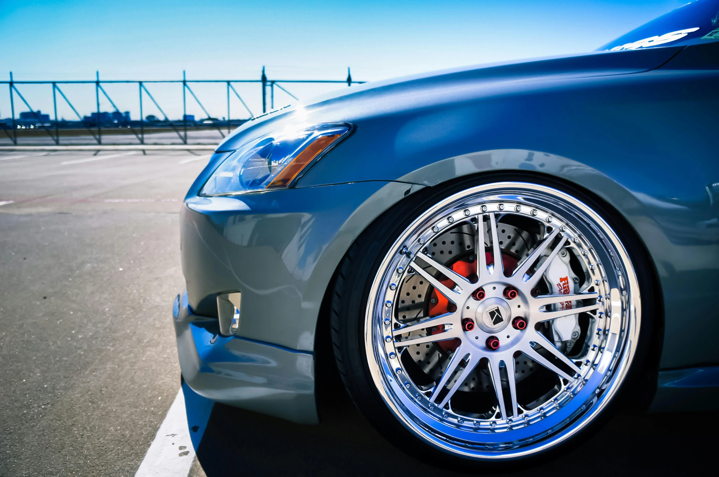 a blue car has chrome wheels and rims on it