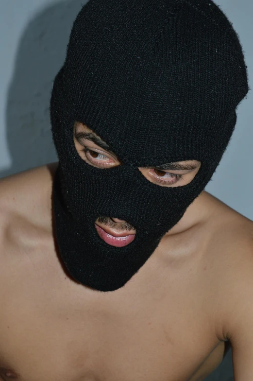 a person wearing a knitted black mask on his face