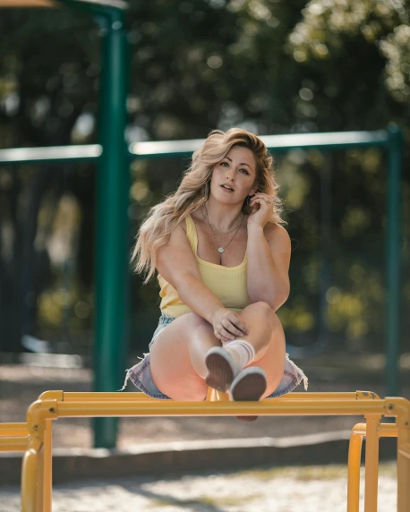 a girl is sitting on the bench in a park