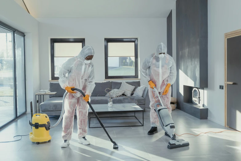 a couple of people with vacuums in a room