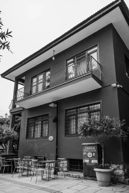 black and white pograph of a building with people sitting in the windows