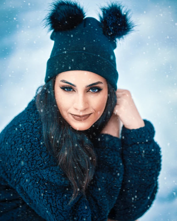 a woman in black coat and hat smiling