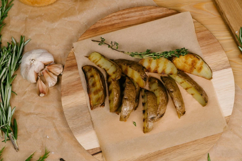 several cooked potatoes on a  board with garlic