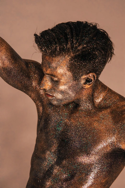 a man with shiny silver paint on his body