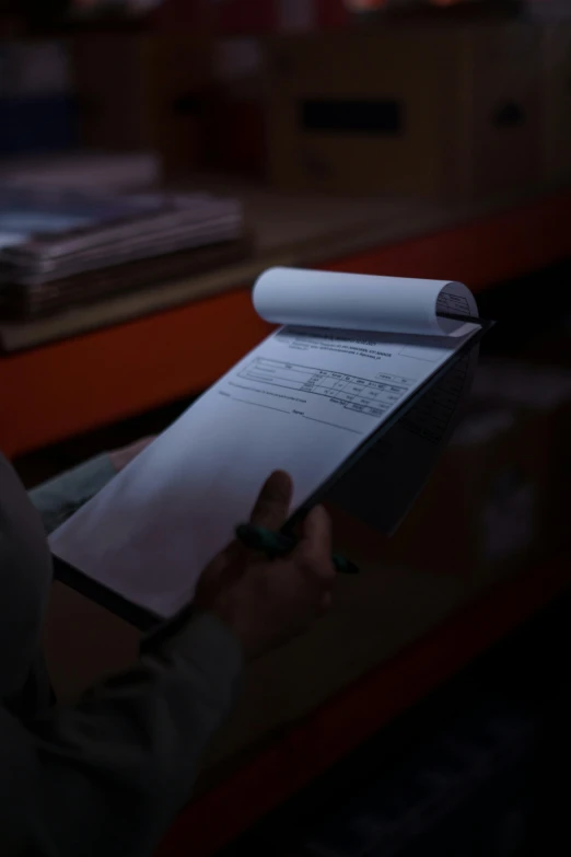 a person holding a piece of paper on top of a table