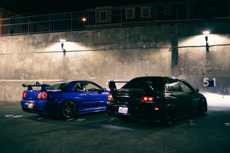 two cars parked in an parking spot at night