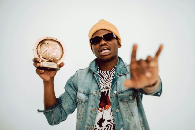 a black man holding a clock in one hand and a peace sign in another hand