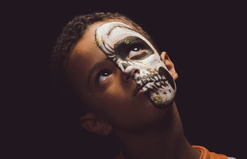 a boy is wearing a skeleton painted mask