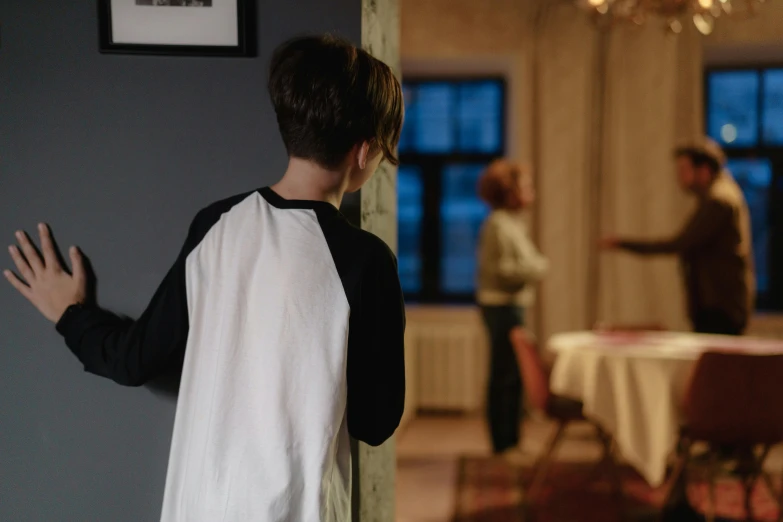 boy with an apron on looking at the reflection in the mirror