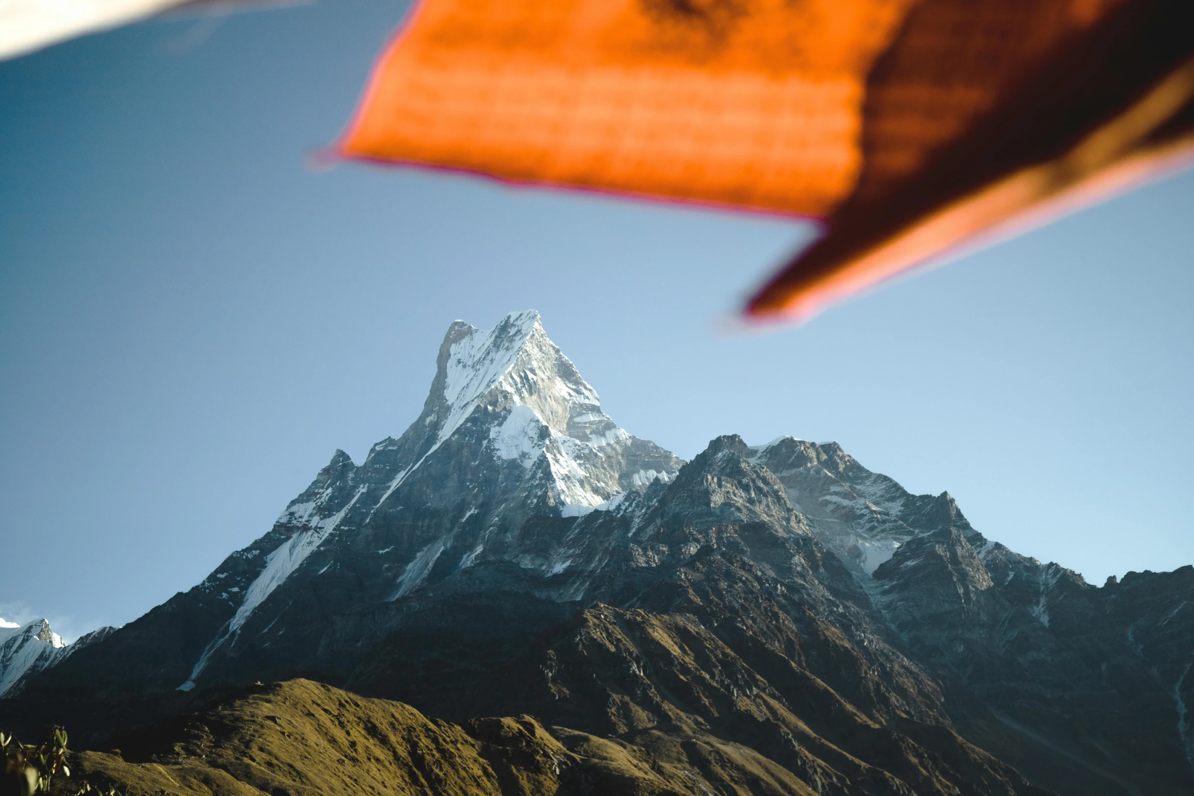 a view of a mountain from below with the sun shining