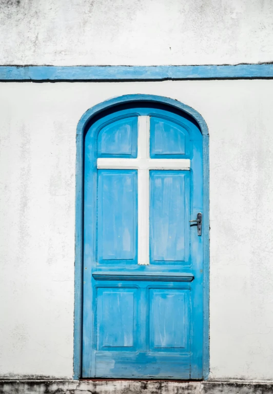 a blue and white door with a cross painted on it