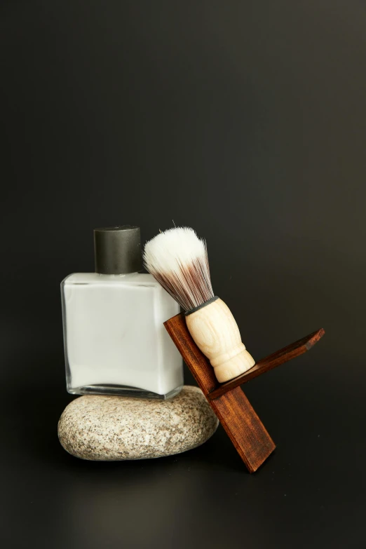 two personal care items including a brush, razor and soap on a rock