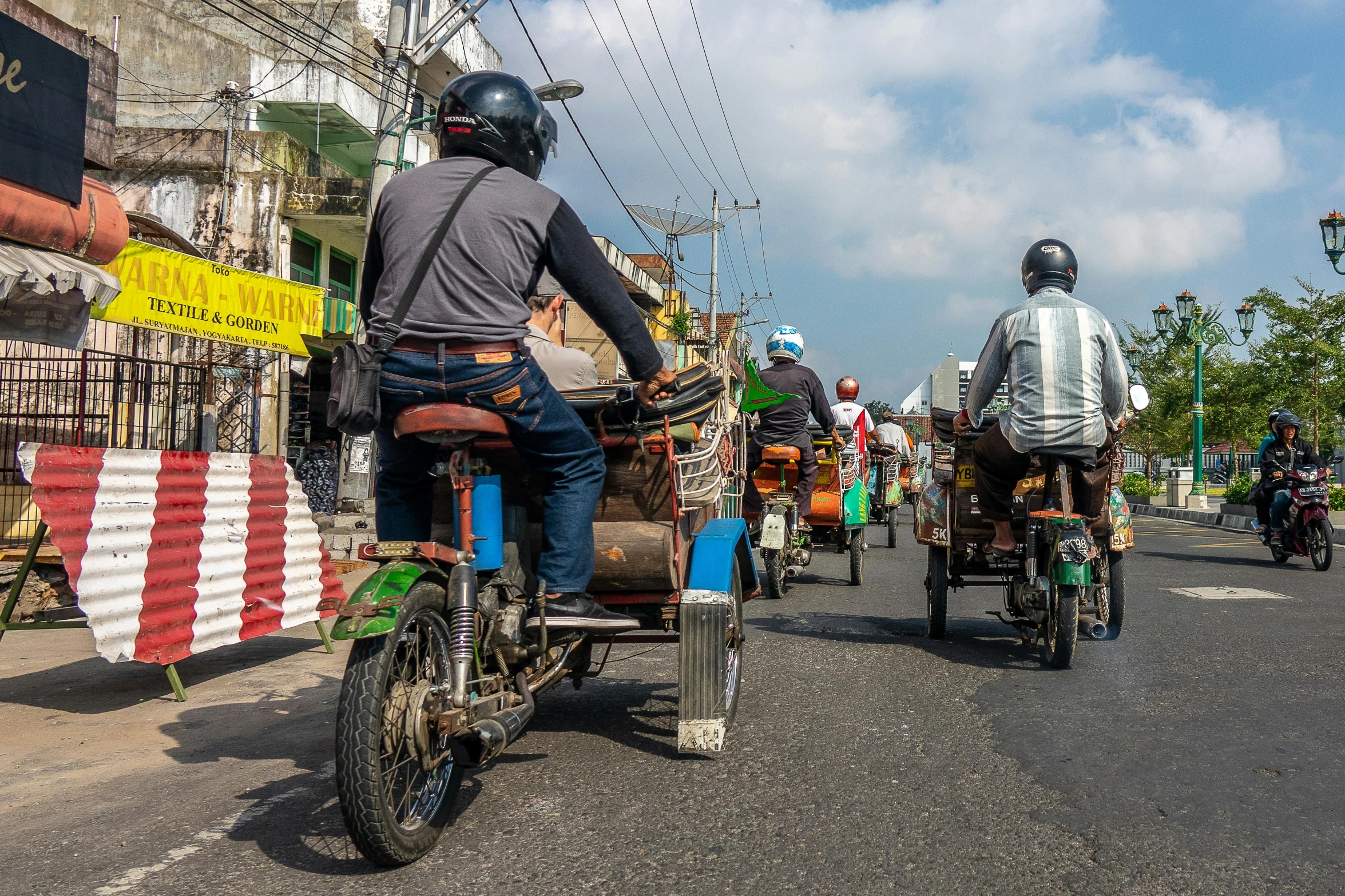 a group of men riding motorcycles down a street