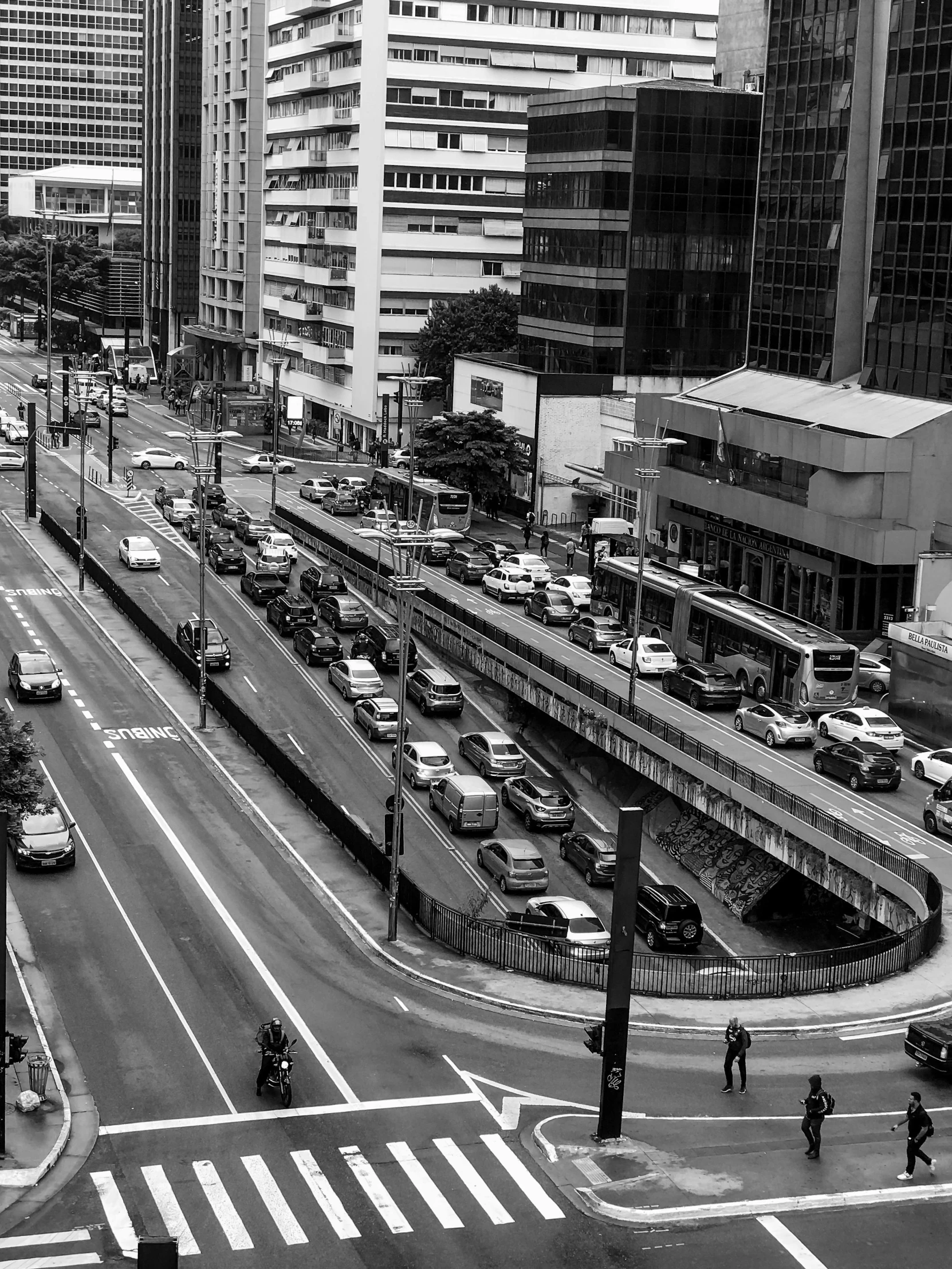 there are several cars and mopeds on this busy street