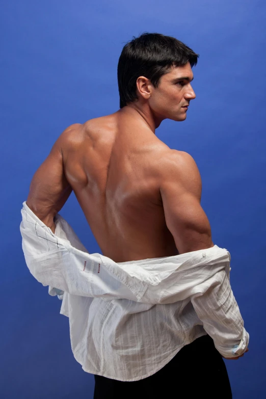 a man without a shirt poses with a white cloth