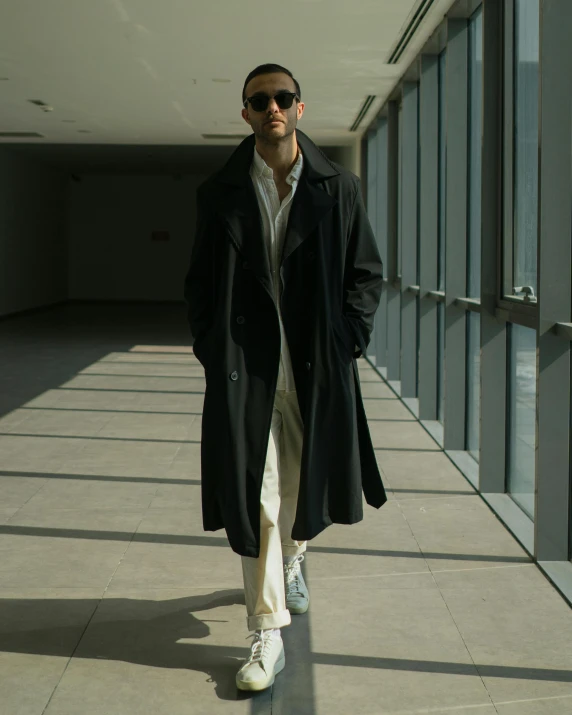 a man in a long coat walking down the street