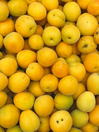 many yellow fruits sit in a bin