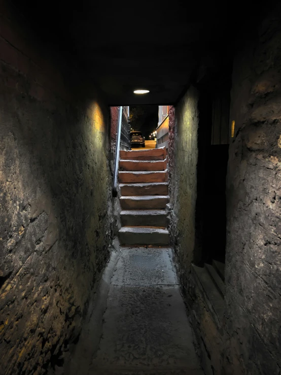 a stairway with stone steps leads to another staircase