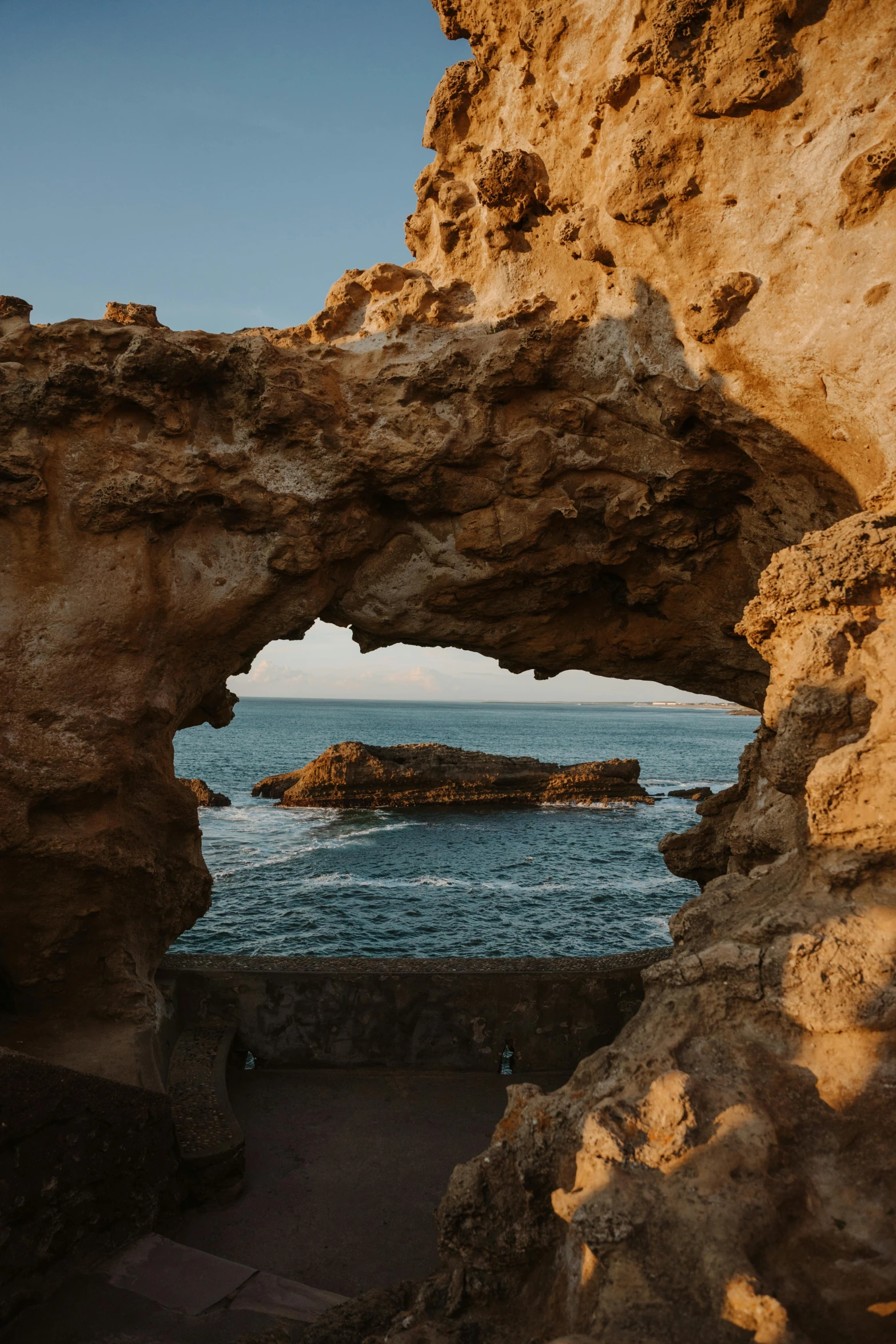 a view out of an arch into the ocean