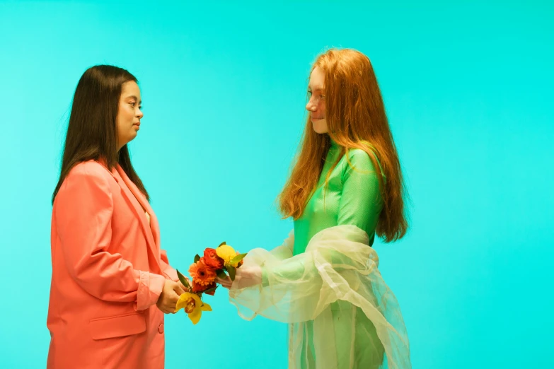 two women talking in front of a blue backdrop