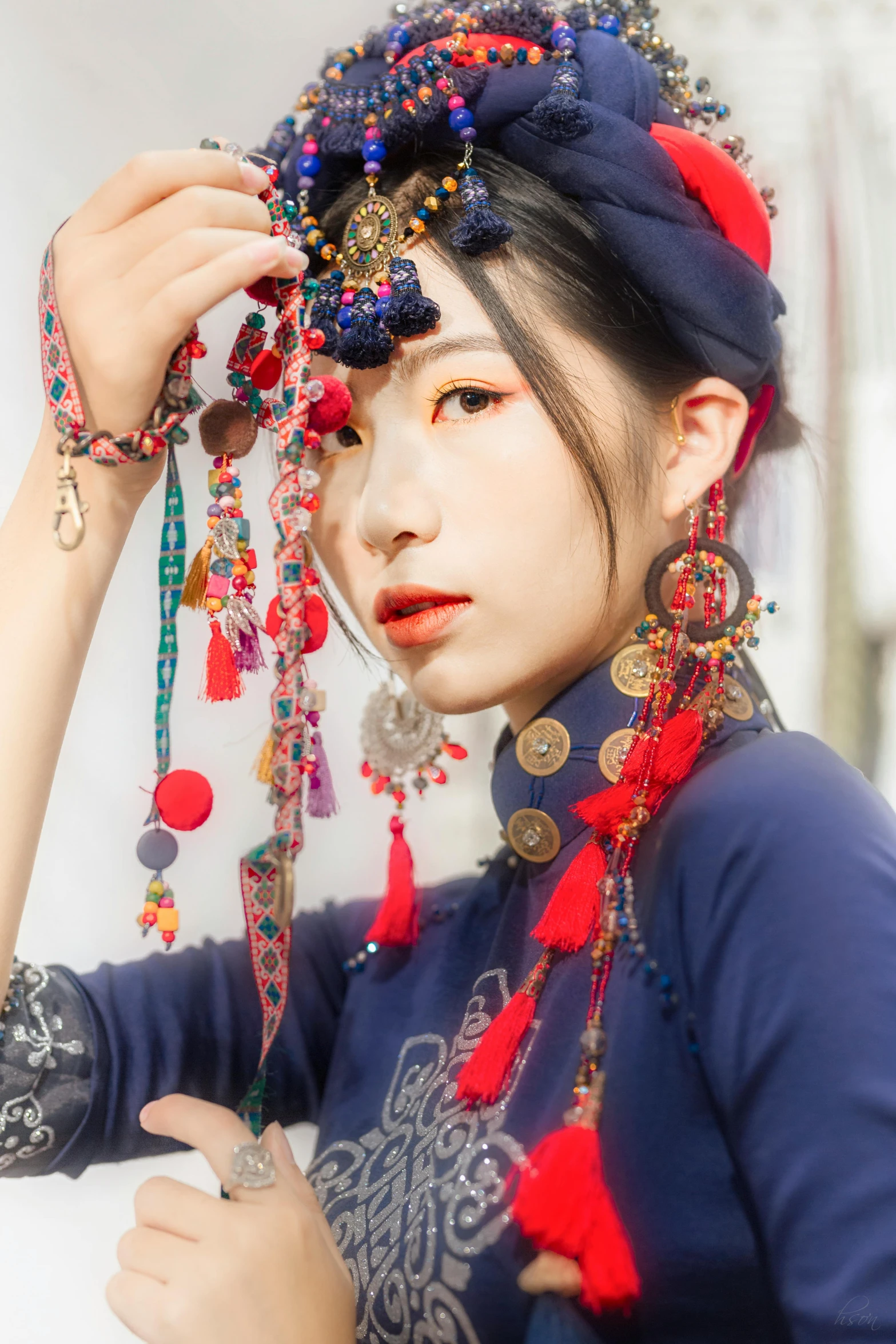 a young woman with a headpiece and many necklaces around her neck