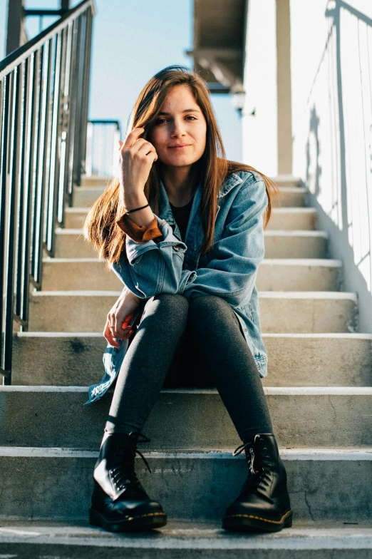 woman sitting on stairs with her hand to her face