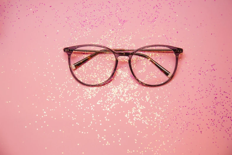a pair of eyeglasses on a pink background
