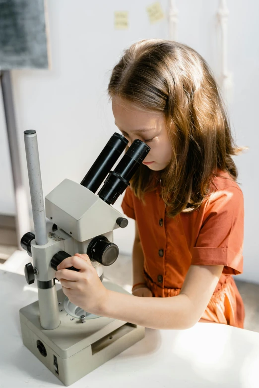 a girl looking through a microscope through the eyes