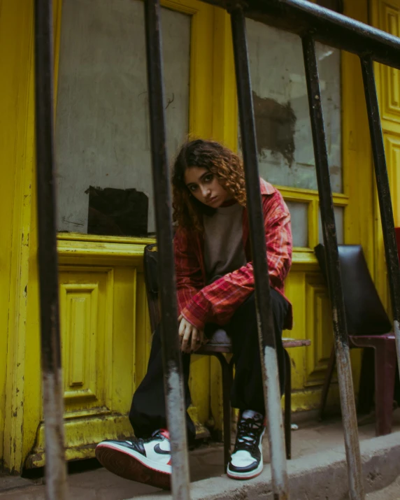 a woman sitting on the steps outside of a building