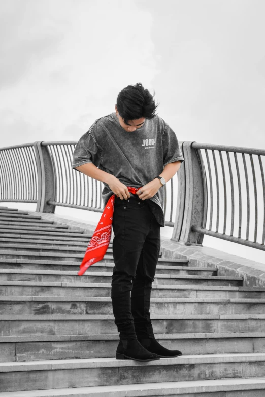 a man with his arms crossed standing on stairs looking down at soing