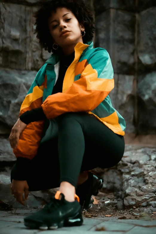 a young woman is sitting outside by rocks