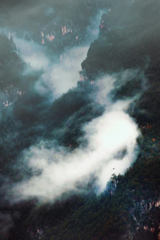 an aerial view of mountains on a cloudy day