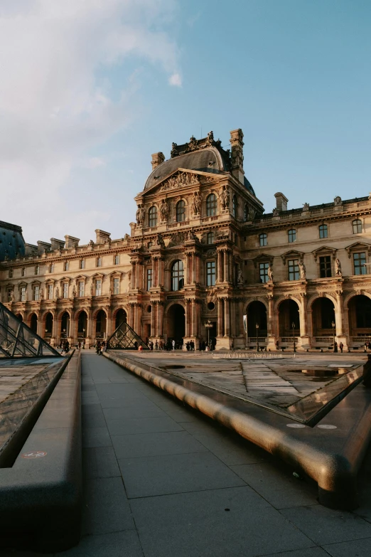 a courtyard that has statues and a pyramid in the background