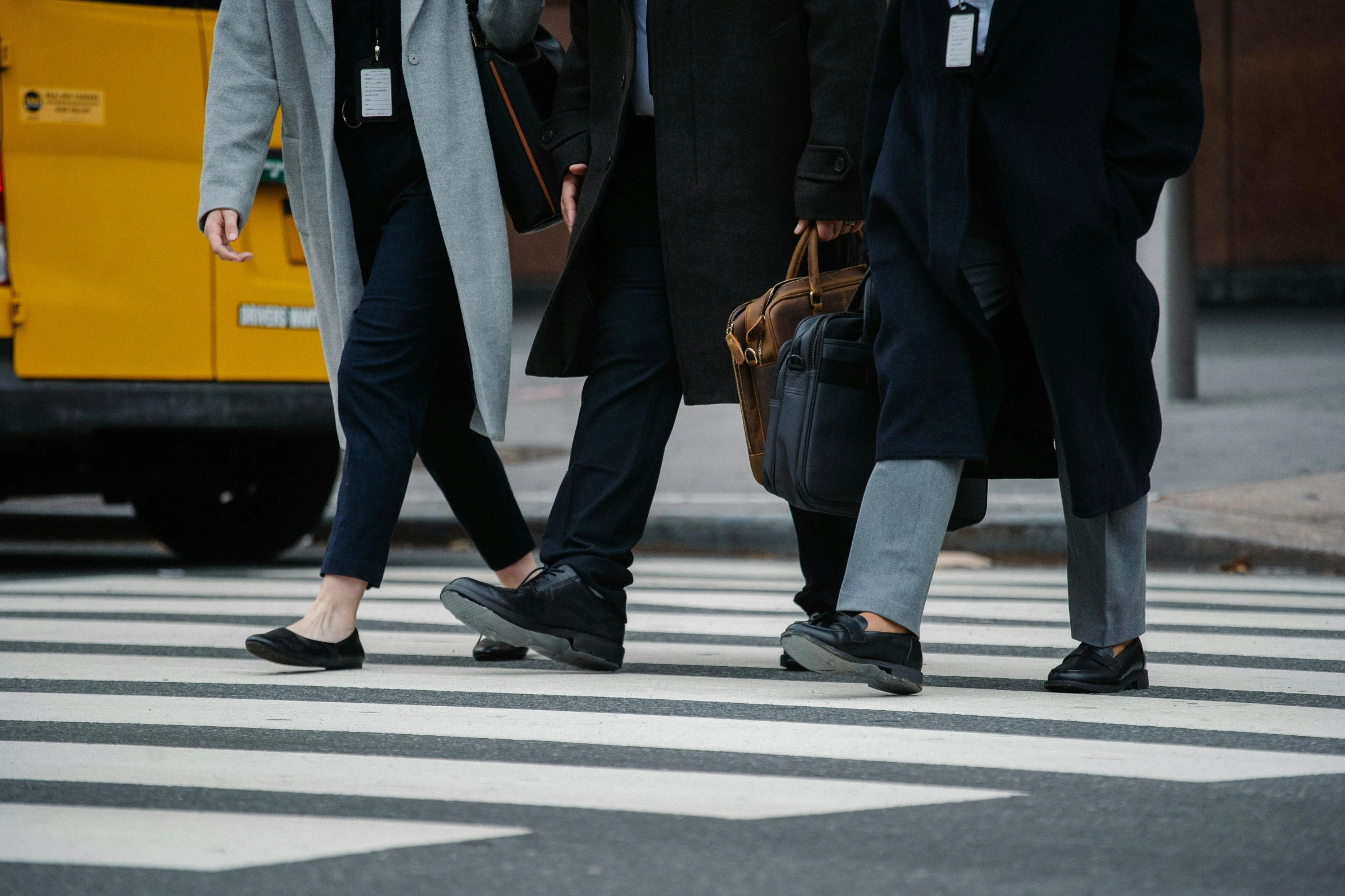 three people walking across a crosswalk in a crosswalk