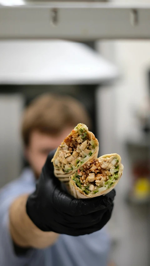 a person holding up a sandwich on a tray