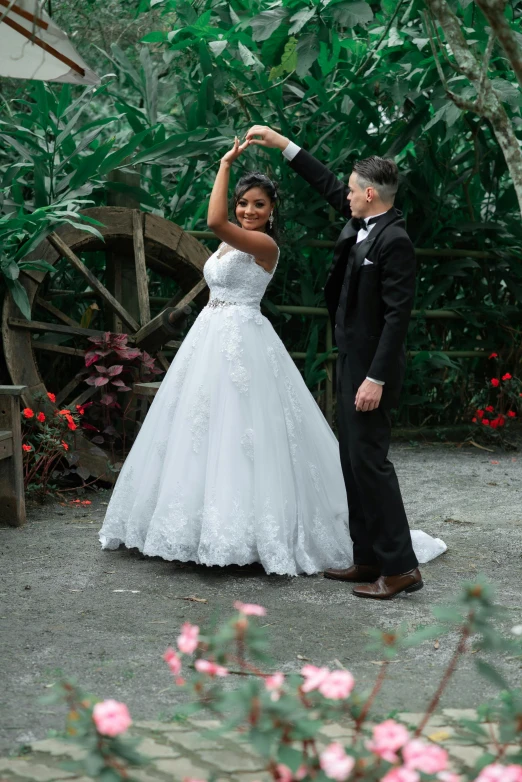 a man and woman dance outside near some flowers