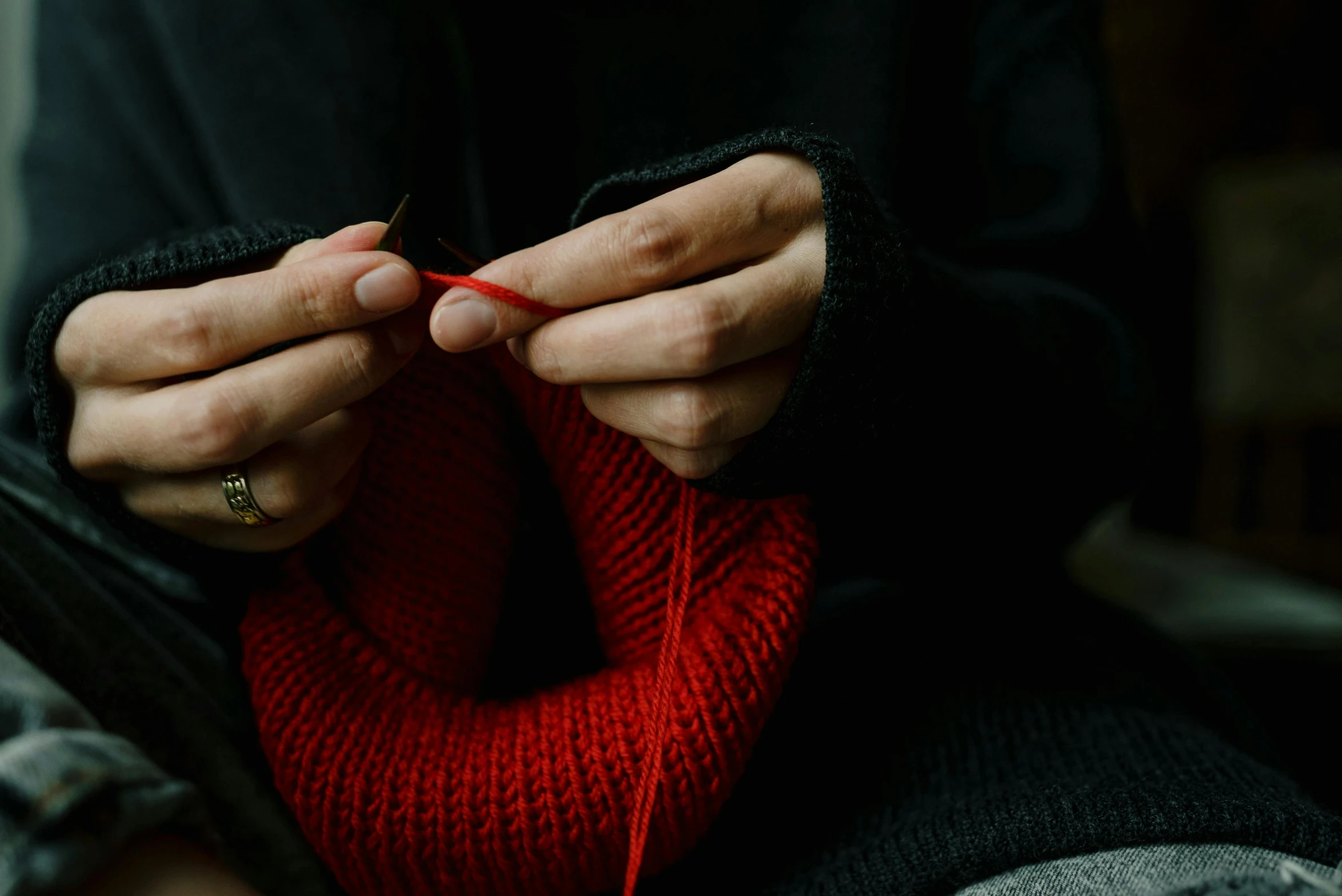 a woman knitting yarn on the end of her hand