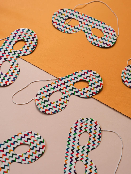 cut out paper pieces with eye shaped circles and some thread