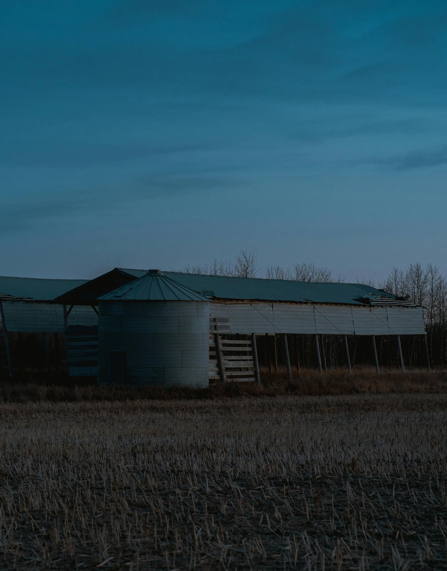 an old shed stands on a farm at dusk