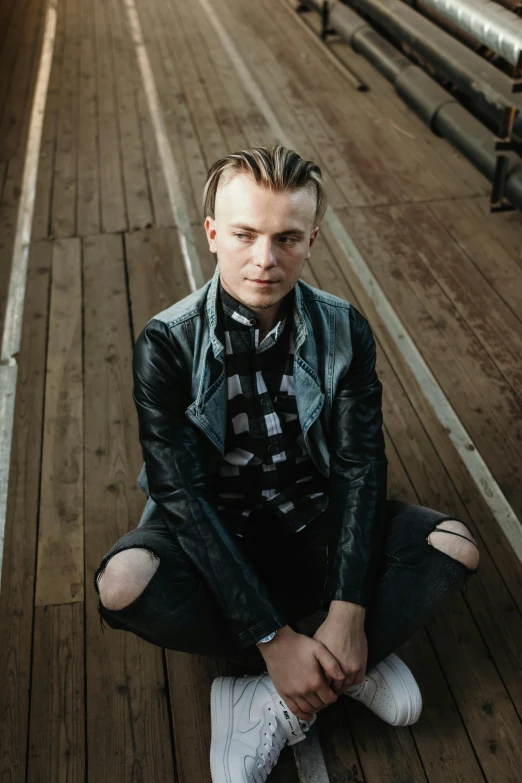 a man sitting on a floor with his hands folded