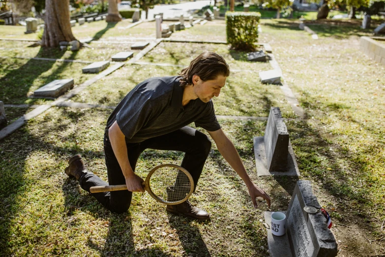 there is a man putting soing in the tombstone