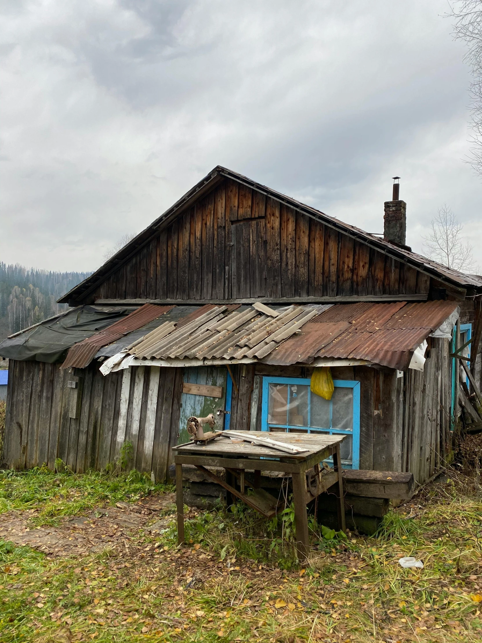 an old wooden house with wood shingles and blue door